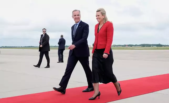 Canada's Prime Minister Mark Carney speaks with U.S. Acting Chief of Protocol Abby Jones, Monday May 5, 2025, as he arrives in Washington, to meet with President Donald Trump. (Adrian Wyld/The Canadian Press via AP)