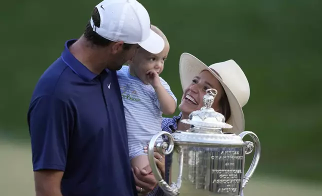 Scottie Scheffler, wife Meredith pose with their son Bennett after winning the PGA Championship golf tournament at the Quail Hollow Club, Sunday, May 18, 2025, in Charlotte, N.C. (AP Photo/Matt York)