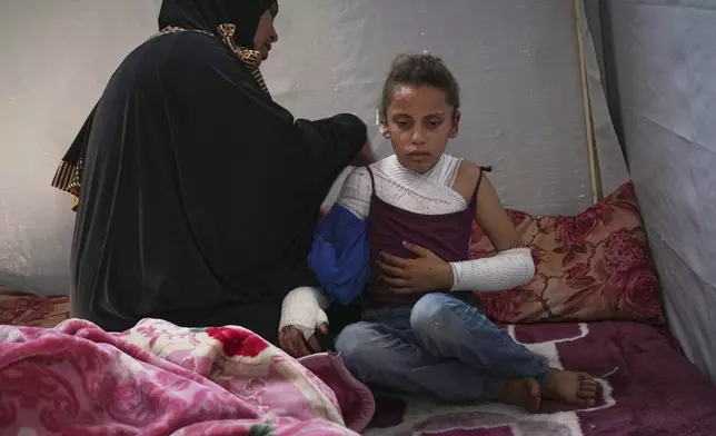Haneen al-Khazandar cares for her 10-year-old daughter Mira who was severely burned on her arms and chest when an Israeli army strike hit near her tent, in Khan Younis, Gaza Strip, Sunday, May 4, 2025.(AP Photo/Abdel Kareem Hana)