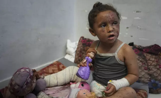 Layan Ibrahim Sahloul, 4, sits despondently among her dolls at Nasser hospital with second-degree burns on her face, foot, and stomach, caused a week earlier during an Israeli army strike on her home in Khan Younis that killed her pregnant mother and two siblings and buried her under the rubble, in Khan Younis, Gaza Strip, Sunday, May 4, 2025.(AP Photo/Abdel Kareem Hana)