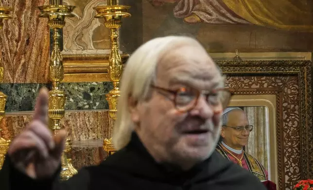 With a picture of Pope Leo XIV in the background, Augustinian friar Alberto Giovannetti, speaks during an interview in the Sanctuary of Our Mother of Good Counsel in Genazzano, Italy, Thursday, May 15, 2025. (AP Photo/Gregorio Borgia)