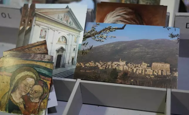 Postcards of the Sanctuary of Our Mother of Good Counsel, left, and of Genazzano, are displayed inside the sanctuary, Thursday, May 15, 2025. (AP Photo/Gregorio Borgia)