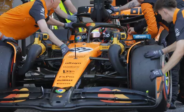 McLaren driver Oscar Piastri of Australia gets pushed back into his garage during the qualifying session ahead of the Spanish Grand Prix Formula One race at the Barcelona Catalunya racetrack in Montmelo, near Barcelona, Spain, Saturday, May 31, 2025. (Juan Medina/Pool Photo via AP)