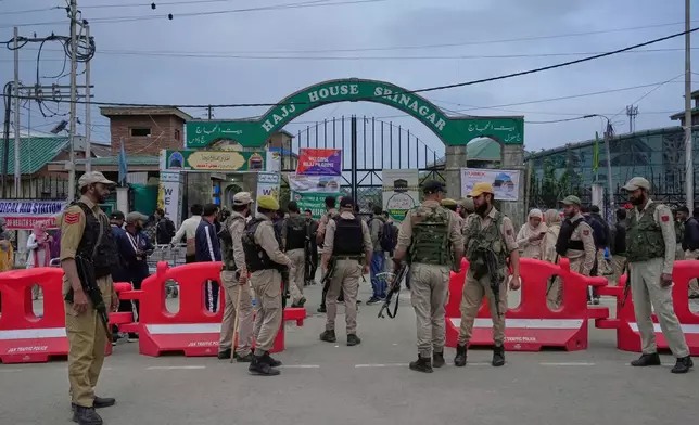 Indian policemen guard outside the Hajj house as the first batch of Kashmiri Muslim pilgrims, departs for the annual pilgrimage to Mecca, Islam's holiest site, in Srinagar, Indian-controlled Kashmir, Sunday, May 4, 2025. (AP Photo/Mukhtar Khan)