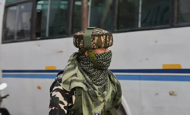 An Indian soldier guards as the first batch of Kashmiri Muslim pilgrims, departs for the annual pilgrimage to Mecca, Islam's holiest site, in Srinagar, Indian-controlled Kashmir, Sunday, May 4, 2025. (AP Photo/Mukhtar Khan)