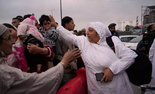 Kashmiri Muslim pilgrims, right, greets to family members and others as the first batch departs for the annual pilgrimage to Mecca, Islam's holiest site, in Srinagar, Indian-controlled Kashmir, Sunday, May 4, 2025. (AP Photo/Mukhtar Khan)