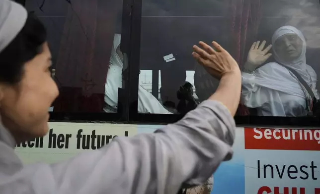Kashmiri Muslim pilgrims wave to relatives and others as the first batch departs for the annual pilgrimage to Mecca, Islam's holiest site, in Srinagar, Indian-controlled Kashmir, Sunday, May 4, 2025. (AP Photo/Mukhtar Khan)