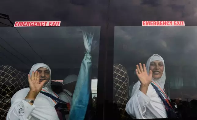 Kashmiri Muslim pilgrims wave to relatives and others as the first batch departs for the annual pilgrimage to Mecca, Islam's holiest site, in Srinagar, Indian-controlled Kashmir, Sunday, May 4, 2025. (AP Photo/Mukhtar Khan)
