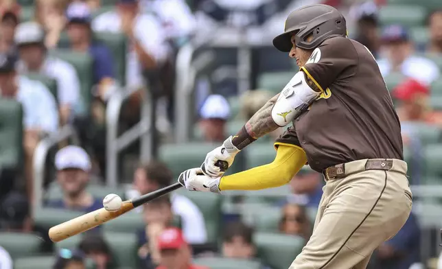 San Diego Padres' Manny Machado hits a double in the first inning of a baseball game against the Atlanta Braves, Sunday, May 25, 2025, in Atlanta. (AP Photo/Colin Hubbard)