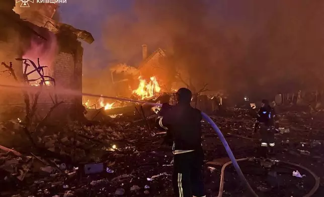In this photo provided by the Ukrainian Emergency Service, firefighters try to put out a fire following a Russian attack in Kyiv region, Ukraine, Sunday, May 25, 2025. (Ukrainian Emergency Service via AP)