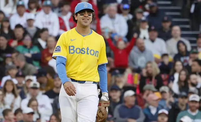 Boston Red Sox third baseman Marcelo Mayer smiles after getting his first out of his career after fielding a ground ball by Baltimore Orioles Ramon Urias in the second inning of the second baseball game of a doubleheader, Saturday, May 24, 2025, at Fenway Park in Boston. (AP Photo/Mary Schwalm)