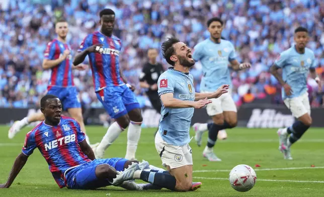 Crystal Palace's Tyrick Mitchell, bottom left, challenges for the ball with Manchester City's Bernardo Silva during the English FA Cup final soccer match between Crystal Palace and Manchester City at Wembley stadium in London, Saturday, May 17, 2025. (AP Photo/Kirsty Wigglesworth)