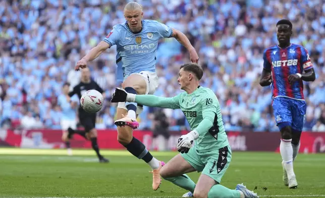 Manchester City's Erling Haaland, left, challenges for the ball with Crystal Palace's goalkeeper Dean Henderson during the English FA Cup final soccer match between Crystal Palace and Manchester City at Wembley stadium in London, Saturday, May 17, 2025. (AP Photo/Kirsty Wigglesworth)