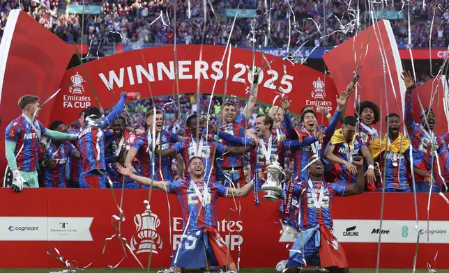 Crystal Palace players celebrate with the trophy after the FA Cup final between Manchester City and Crystal Palace at the Wembley Stadium in London, Saturday, May 17, 2025. (AP Photo/Ian Walton)