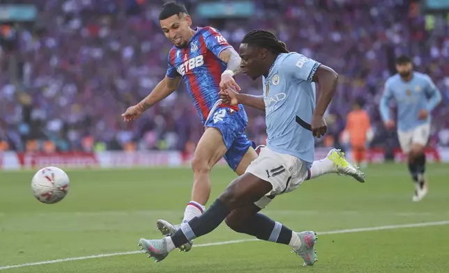 Manchester City's Jeremy Doku sends a cross by Crystal Palace's Daniel Munoz during the FA Cup final between Manchester City and Crystal Palace at the Wembley Stadium in London, Saturday, May 17, 2025. (AP Photo/Ian Walton)
