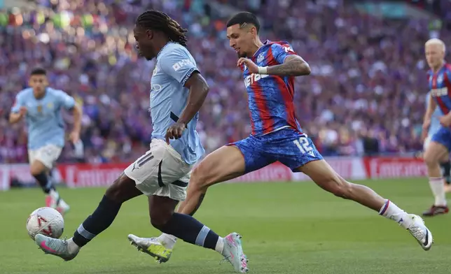 Manchester City's Jeremy Doku sends a cross by Crystal Palace's Daniel Munoz during the FA Cup final between Manchester City and Crystal Palace at the Wembley Stadium in London, Saturday, May 17, 2025. (AP Photo/Ian Walton)
