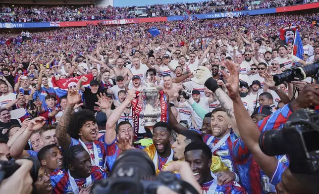 Crystal Palace players celebrate with the trophy after the FA Cup final between Manchester City and Crystal Palace at the Wembley Stadium in London, Saturday, May 17, 2025. (AP Photo/Ian Walton)
