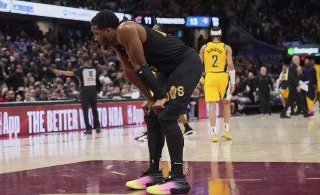 Cleveland Cavaliers guard Donovan Mitchell, left, takes a break during a timeout in the second half in Game 5 of an Eastern Conference semifinal NBA basketball playoff against the Indiana Pacers, Tuesday, May 13, 2025, in Cleveland. (AP Photo/Sue Ogrocki)