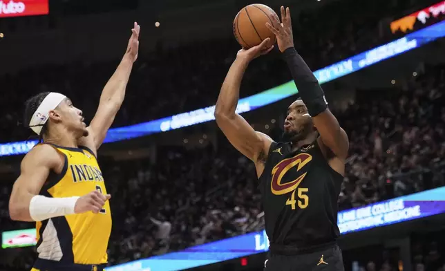 Cleveland Cavaliers guard Donovan Mitchell, right, shoots as Indiana Pacers guard Andrew Nembhard defends during the second half in Game 5 of an Eastern Conference semifinal NBA basketball playoff Tuesday, May 13, 2025, in Cleveland. (AP Photo/Sue Ogrocki)