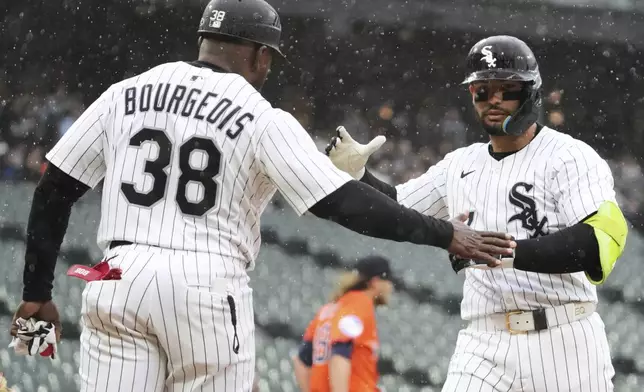 Chicago White Sox's Edgar Quero, right, celebrates with first base coach Jason Bourgeois (38) after hitting a one-run single during the sixth inning of a baseball game against the Houston Astros in Chicago, Sunday, May 4, 2025. (AP Photo/Nam Y. Huh)