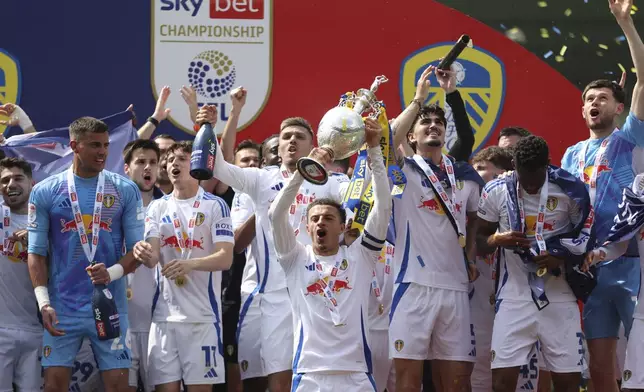 Leeds United's Ethan Ampadu and teammates celebrate with the trophy after being crowned champions following the English Football League Championship soccer match against Plymouth Argyle, at Home Park, in Plymouth, England, Saturday May 3, 2025. (Steven Paston/PA via AP)