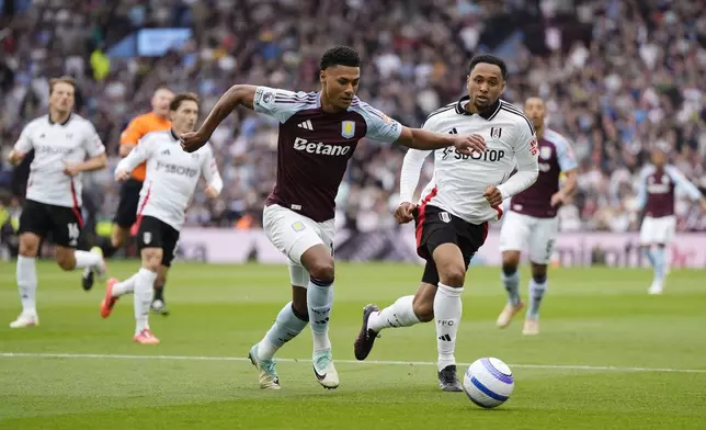 Aston Villa's Ollie Watkins, centre, and Fulham's Kenny Tete battle for the ball during the English Premier League soccer match between Aston Villa and Fulham at Villa Park, Birmingham, England, Saturday, May 3, 2025. (Nick Potts/PA via AP)