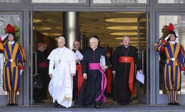 Pope Leo XIV, left, is flanked by Monsignor Leonardo Sapienza, second from left, after his meeting with the College of Cardinals in the New Synod Hall at the Vatican, Saturday, May 10, 2025. (Vatican Media via AP)