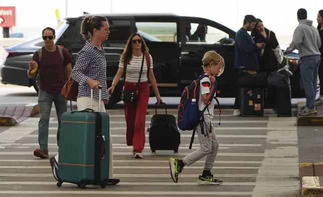 Travelers head to the check-in counters for their flights in the main terminal of Denver International Airport Friday, May 23, 2025. (AP Photo/David Zalubowski)