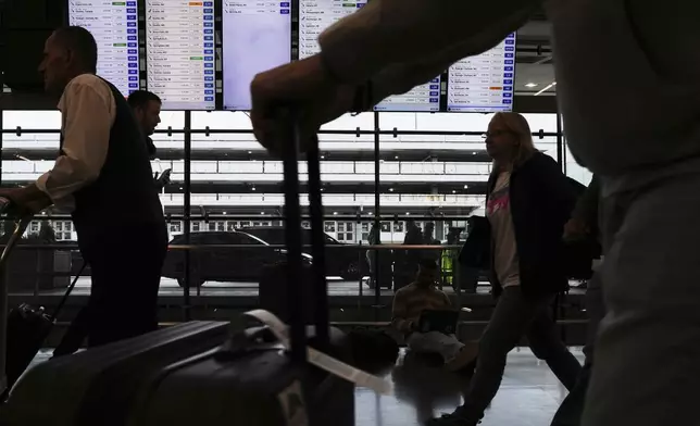 Travelers walk with their luggage in terminal 3 at O'Hare International Airport in Chicago, Friday, May 23, 2025. (AP Photo/Nam Y. Huh)