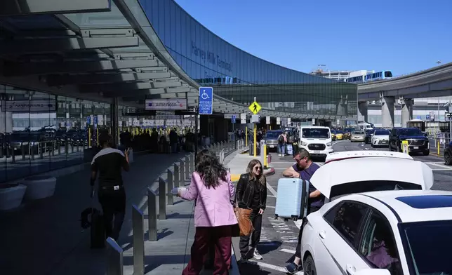 Travelers arrive at San Francisco International Airport ahead of the Memorial Day holiday weekend in San Francisco, Thursday, May 22, 2025. (AP Photo/Godofredo A. Vásquez)