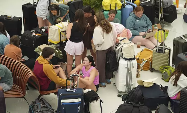 Travelers gather to wait for their flights in the main terminal of Denver International Airport Friday, May 23, 2025, in Denver. (AP Photo/David Zalubowski)