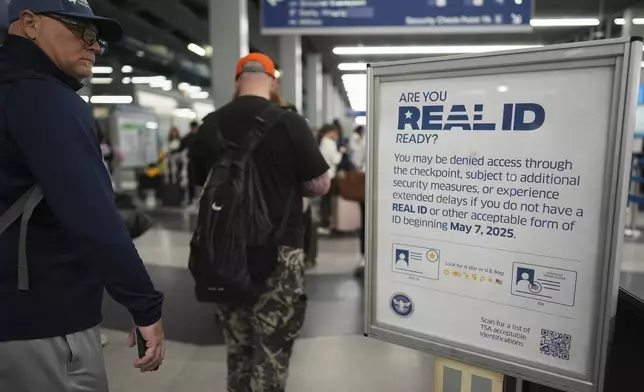 A traveler glances at a Real ID sign posted inside of terminal 3 at O'Hare International Airport in Chicago, Friday, May 23, 2025. (AP Photo/Nam Y. Huh)