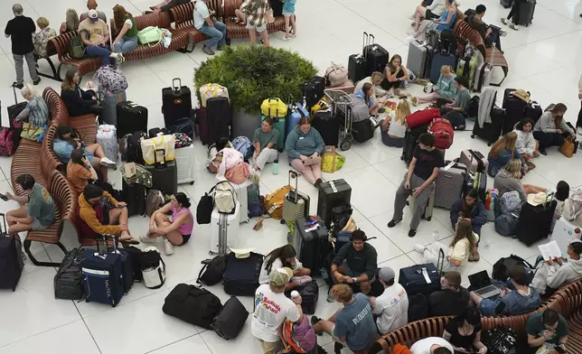 Travellers gather to wait for their flights in the main terminal of Denver International Airport Friday, May 23, 2025, in Denver. (AP Photo/David Zalubowski)