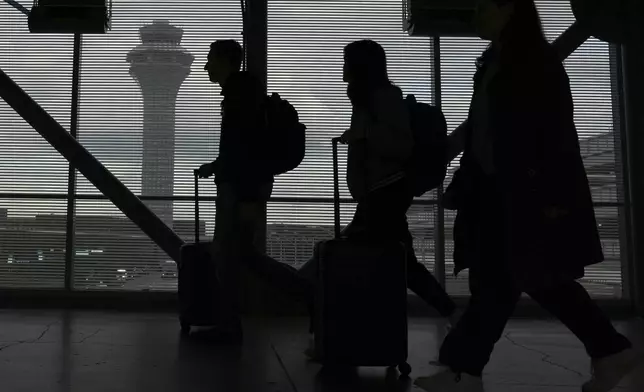 Travelers walk through the skyway leading to terminal 3 at O'Hare International Airport in Chicago, Friday, May 23, 2025. (AP Photo/Nam Y. Huh)