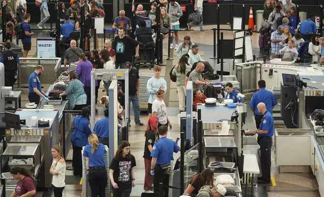 Travelers queue up at the south security checkpoint in Denver International Airport Friday, May 23, 2025. (AP Photo/David Zalubowski)
