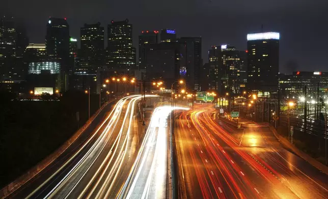In this long exposure photograph traffic moves along Interstate 76 ahead of the Memorial Day holiday weekend, in Philadelphia, Thursday, May 22, 2025. (AP Photo/Matt Rourke)