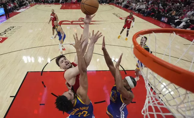 Houston Rockets center Alperen Sengun shoots over Golden State Warriors forward Trayce Jackson-Davis (32) and guard Moses Moody (4) during the second half of Game 5 of an NBA basketball first-round playoff series, Wednesday, April 30, 2025, in Houston. (AP Photo/David J. Phillip)