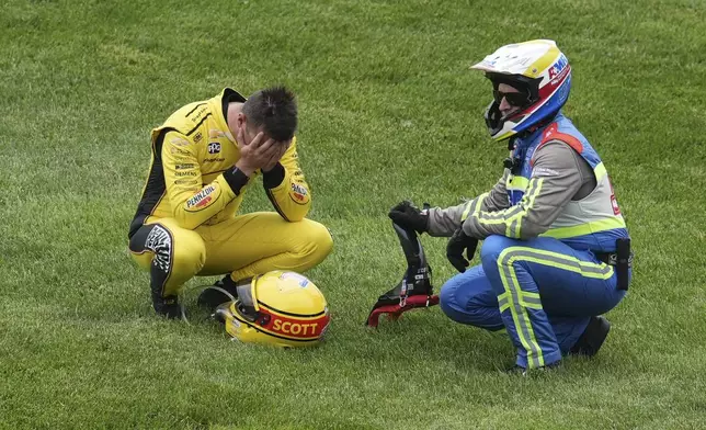 Scott McLaughlin, of New Zealand, holds his head in his hands after a crash on the parade lap on the start of the Indianapolis 500 auto race at Indianapolis Motor Speedway in Indianapolis, Sunday, May 25, 2025. (AP Photo/Michael Conroy)