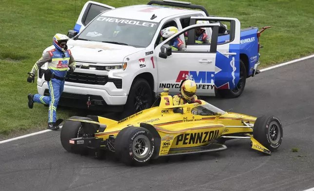 Scott McLaughlin, of New Zealand, climbs out of his car after a crash on the parade lap on the start of the Indianapolis 500 auto race at Indianapolis Motor Speedway in Indianapolis, Sunday, May 25, 2025. (AP Photo/Michael Conroy)