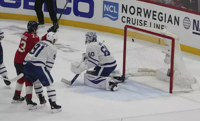 Toronto Maple Leafs goaltender Joseph Woll (60) looks the other way as a shot by Florida Panthers center Brad Marchand enters the goal to win the game in overtime in Game 3 of a second-round NHL hockey playoff series, Friday, May 9, 2025, in Sunrise, Fla. (AP Photo/Marta Lavandier)