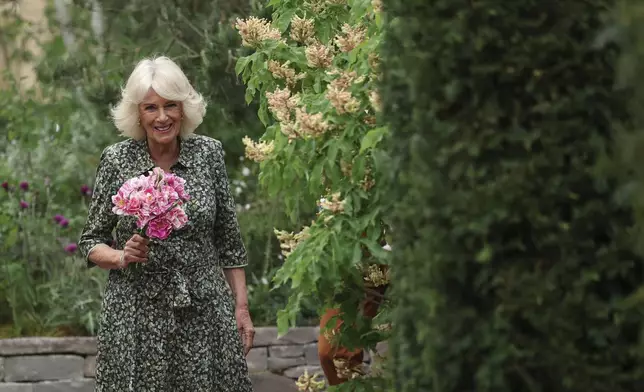 Britain's Queen Camilla holds roses called "The King's Rose" of David Austin Roses at the Chelsea Flower Show in London, Monday May 19, 2025. (Toby Melville/Pool via AP)