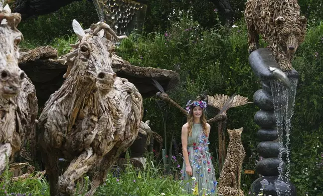 Cordelia Bellew walks through a garden displaying James Doran-Webb Driftwood Sculptures at the RHS Chelsea Flower Show in London, Monday, May 19, 2025. (AP Photo/Kirsty Wigglesworth)