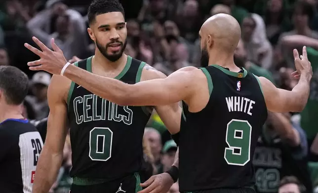 Boston Celtics forward Jayson Tatum (0) celebrates with teammate Derrick White while leading the Orlando Magic during the second half in Game 5 of a first-round NBA playoff basketball series, Tuesday, April 29, 2025, in Boston. (AP Photo/Charles Krupa)