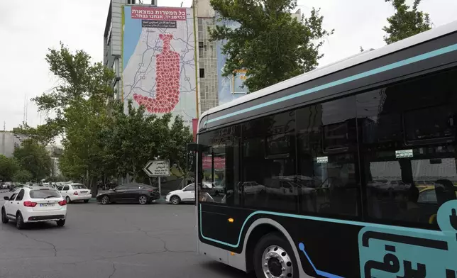 Vehicles drive past an anti-Israel banner showing numerous locations in Israel as a Yemeni dagger (jambiya) with writing in Farsi reading: "All targets are within range, Yemeni missiles for now!", and in Hebrew "All targets are within reach, we will choose", at the Felestin (Palestine) Sq. in downtown Tehran, Iran, Monday, May 5, 2025. (AP Photo/Vahid Salemi)