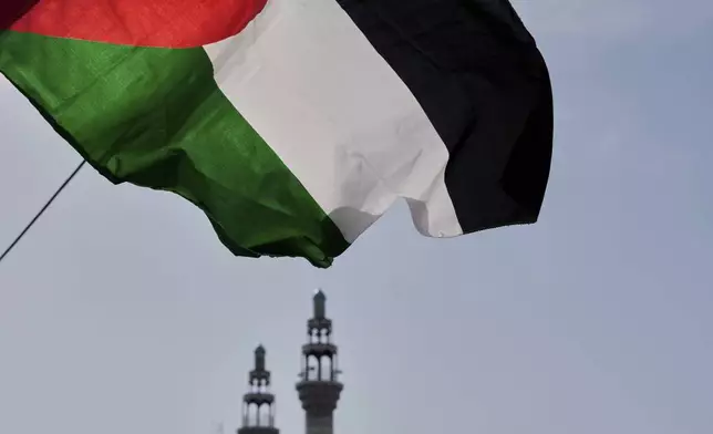 A Palestinian flag waves with the minarets of a mosque in the background during a pro-Palestinian gathering in Tehran, Iran, Friday, May 2, 2025. (AP Photo/Vahid Salemi)