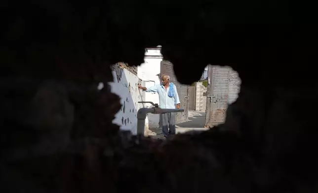 A villager shows the wall of his house riddled with shrapnels from Pakistani artillery shelling at RS Pura, along the International Border, India, Monday, May 12, 2025. (AP Photo/Channi Anand)