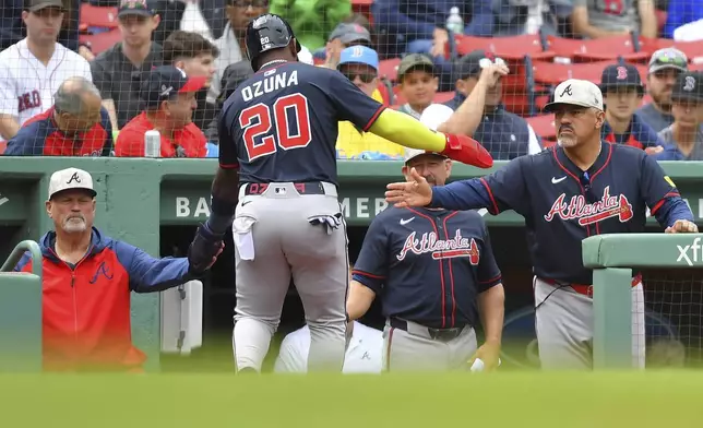 Atlanta Braves' Marcell Ozuna (20) is welcomed to the dugout after scoring on a bases-loaded walk in the fifth inning of a baseball game against the Boston Red Sox, Sunday, May 18, 2025, in Boston. (AP Photo/Steven Senne)