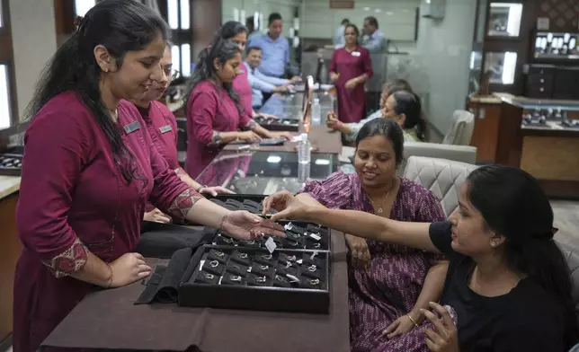A salesperson shows a diamond ring to a prospective buyer at a jewelry shop in Ahmedabad, India, on April 14, 2025. (AP Photo/Ajit Solanki)