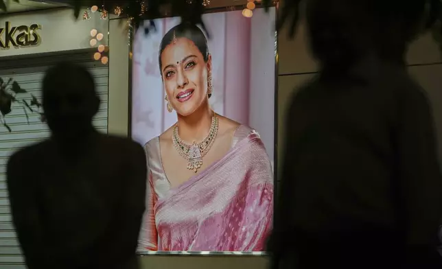 An advertising poster featuring Bollywood actor Kajol is displayed outside a jewelry shop in Ahmedabad, India, on April 14, 2025. (AP Photo/Ajit Solanki)
