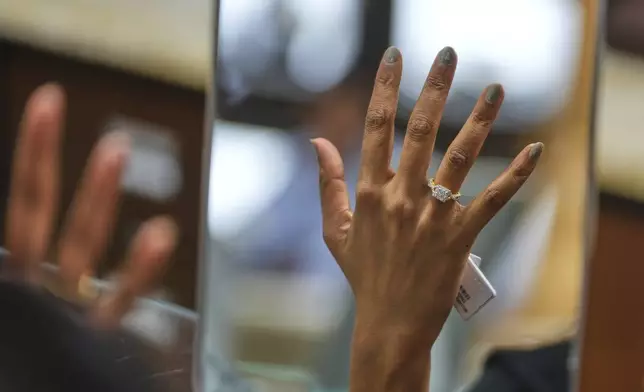 A woman tries on a diamond ring at a jewelry shop in Ahmedabad, India, on April 14, 2025. (AP Photo/Ajit Solanki)